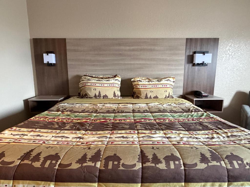 a bed in a hotel room with a large bed at Booneslick Lodge - Neosho in Neosho