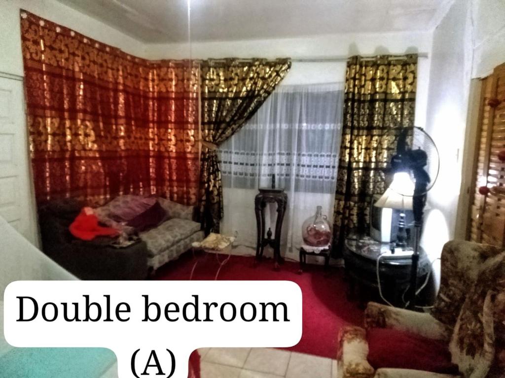 una sala de estar con sofá y una habitación doble en Captain Morgan House, en Kingston