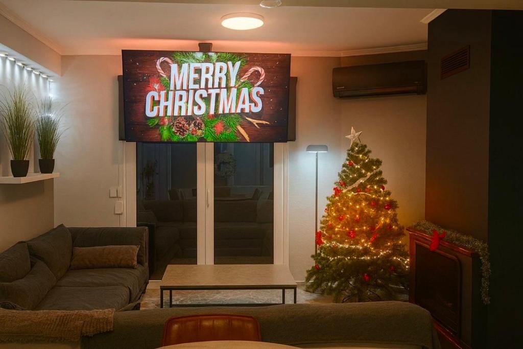 sala de estar con TV y árbol de Navidad en Sountou home, en Xanthi