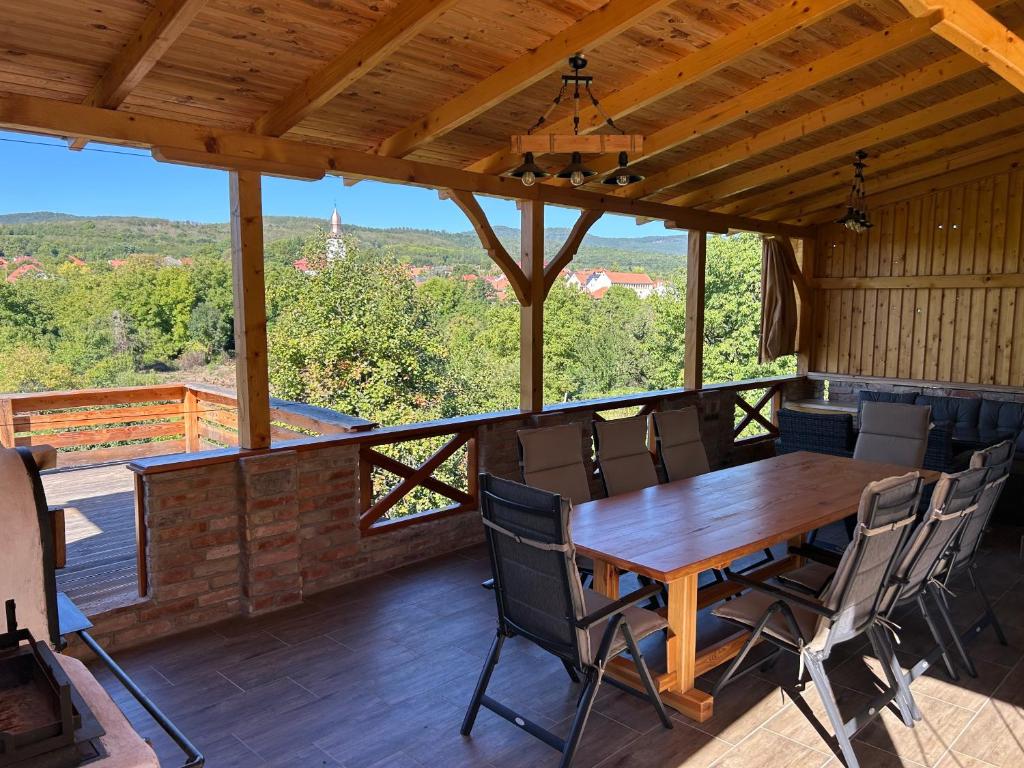 a wooden table and chairs on a deck with a view at Panoráma Terasz Vendégház in Noszvaj