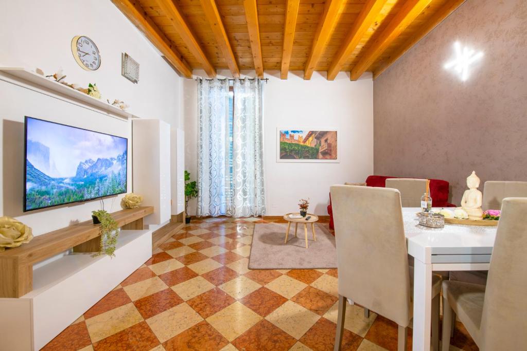 ein Wohnzimmer mit Tisch und Fernseher in der Unterkunft Mazzini Luxury Suite in Verona