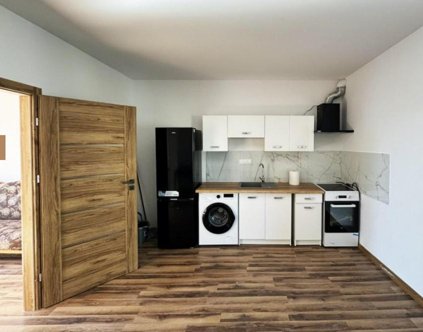 a kitchen with white appliances and a black refrigerator at Świecie Apartament Biznesowy in Świecie