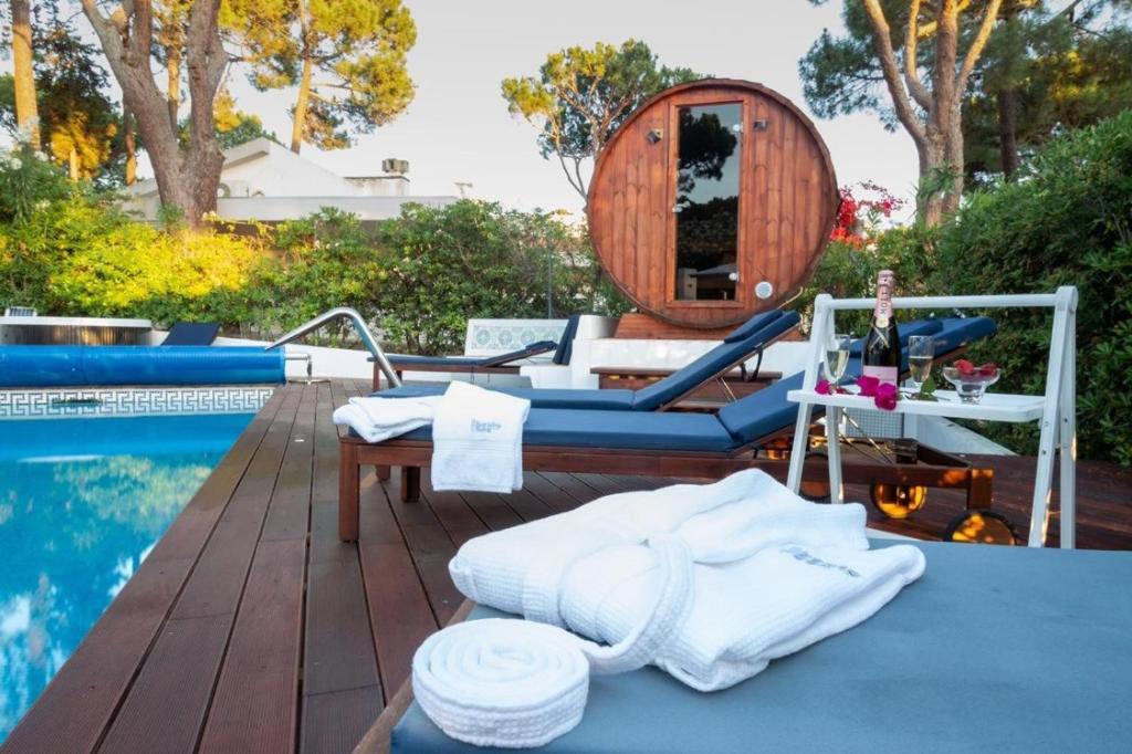 Un patio trasero con una piscina con un columpio y una mesa. en Bento Box Villa Family Hub Fitness, en Vilamoura