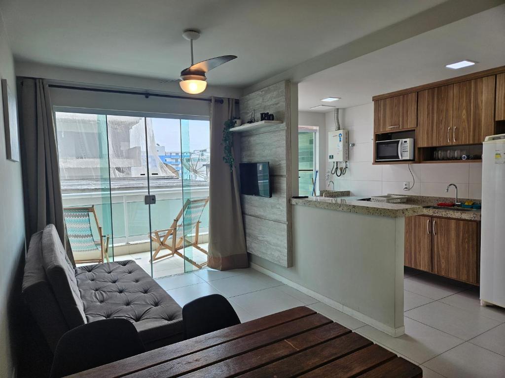 een keuken met een bank en een tafel in een kamer bij PORTO AZUL - Praia do Forte - Apart in Cabo Frio