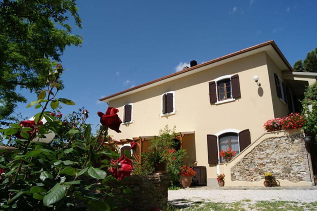 een groot huis met bloemen ervoor bij Appartamento Papavero Seaside and Pool in La Caduta