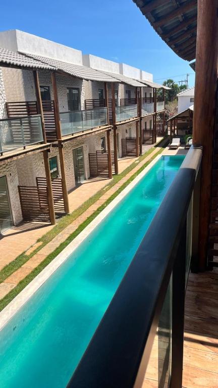 a large swimming pool in front of a building at Chalé da Barra EG in Barra Grande