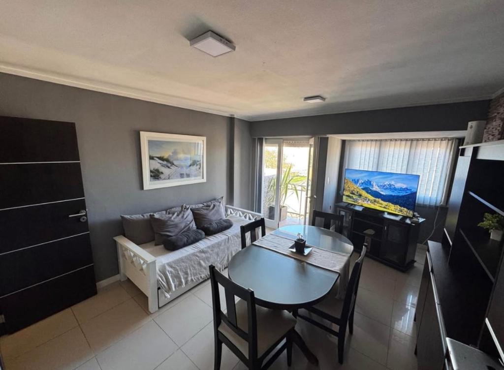 salon z kanapą i stołem w obiekcie Depto Comahue Playa Necochea w mieście Necochea