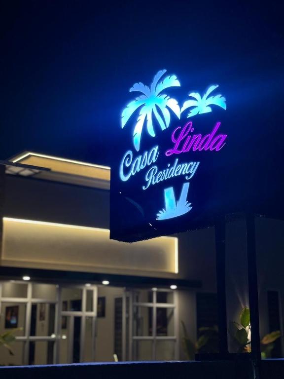 a neon sign for a restaurant with palm trees on it at Casa Linda Residency in Varkala