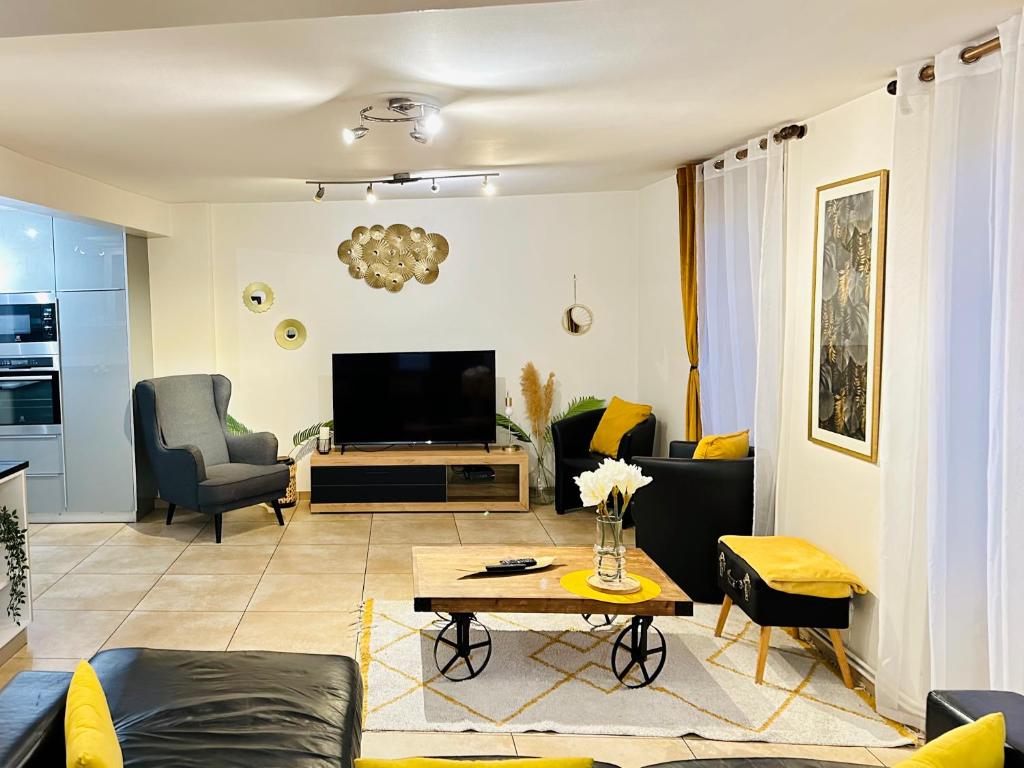 ein Wohnzimmer mit Sofa und Fernseher in der Unterkunft Maison Le V - Proche Disney in Montévrain
