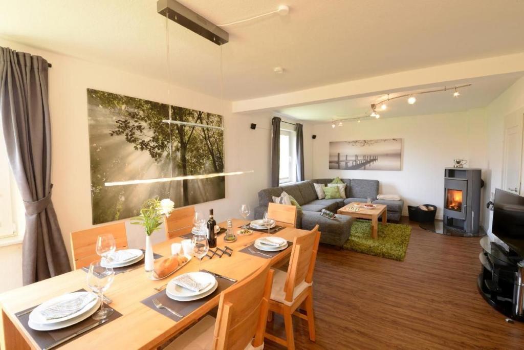 un salon avec une table à manger et un canapé dans l'établissement Ruhiges Ferienhaus In Lommersdorf Mit Garten, à Blankenheim