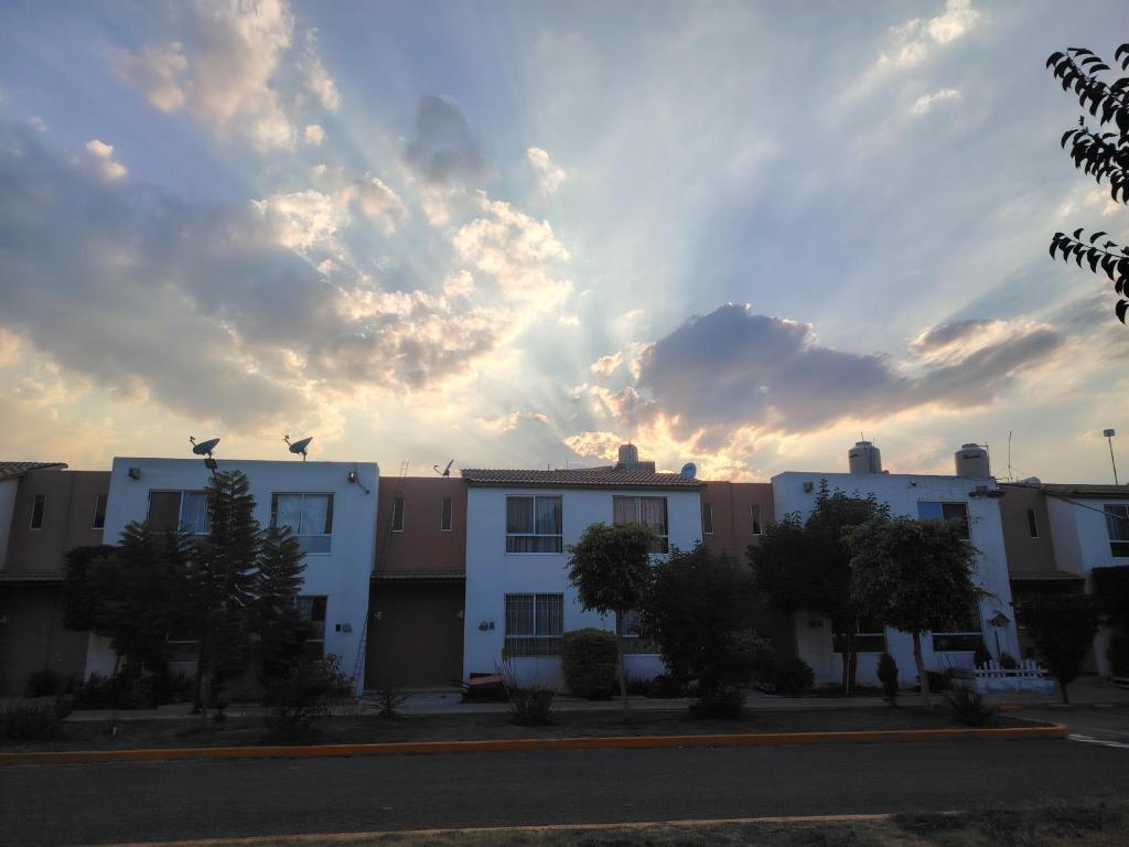 un grupo de edificios con un cielo nublado en el fondo en Recamara, en Coyotillos
