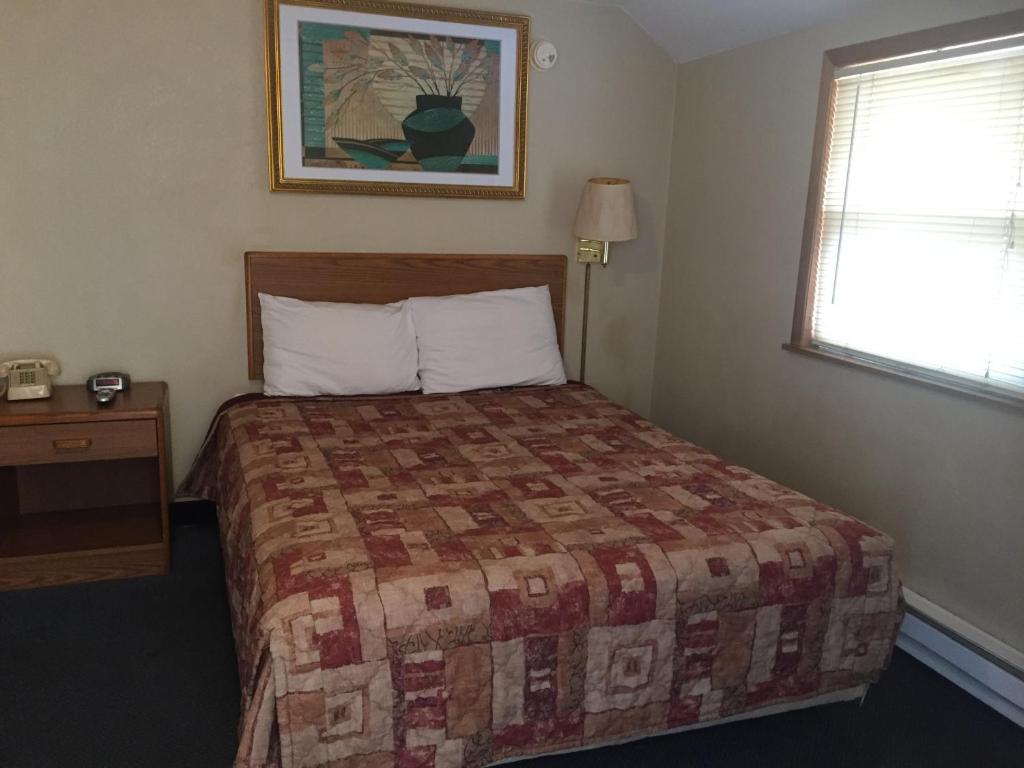 a hotel room with a bed and a window at West Motel in Freeport