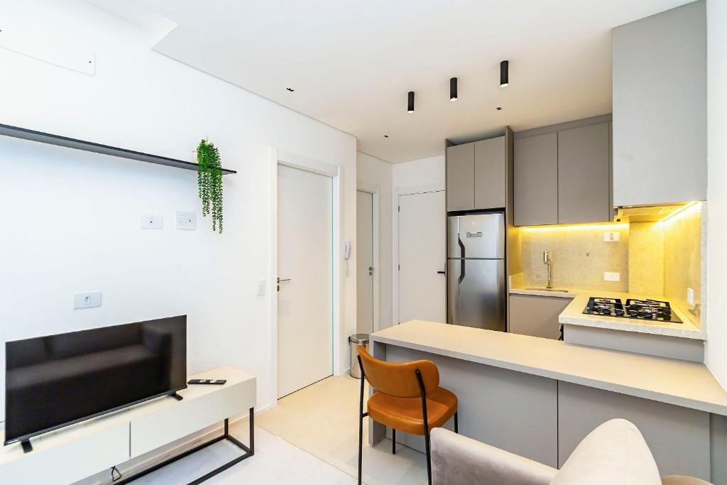 a kitchen with white cabinets and a counter with a tv at Apto em prédio com Piscina, Região Nobre - TEM0205 in Curitiba
