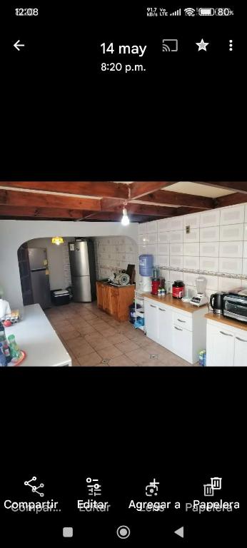 Arriendo habitación amobladas singles a turistas sector centro de la serena في لا سيرينا: مطبخ مع أجهزة بيضاء وصورة سوداء