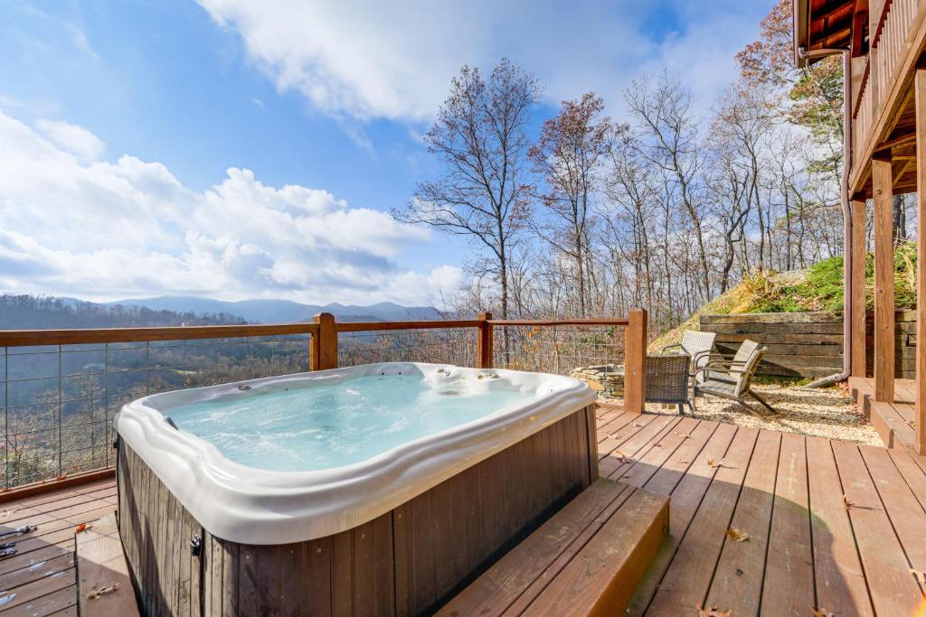 a hot tub on the deck of a house at Elevated Cabin Bordering Smoky Mountain Nat'l Park in Bryson City