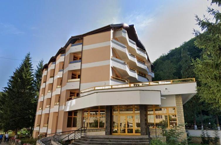 a large building with stairs in front of it at Montana Inn Slănic Moldova in Slănic-Moldova