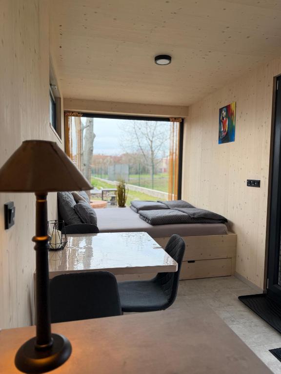 a room with three beds and a table with a lamp at Upcyklovaný kontejnerový dům in Pardubice