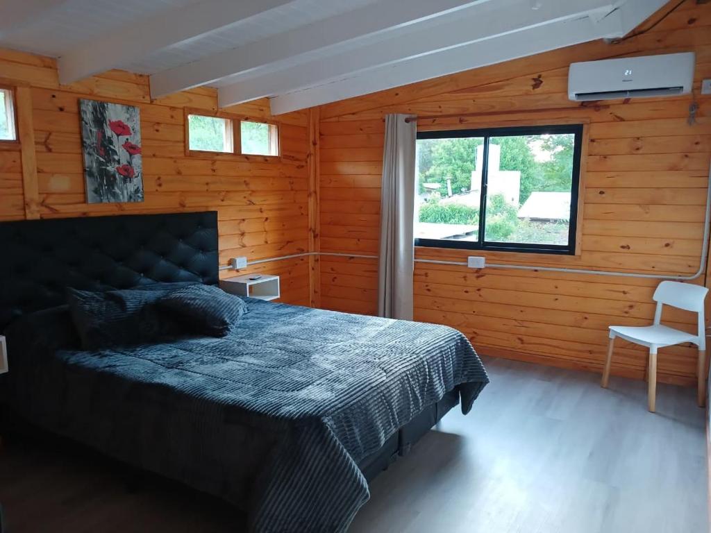 Villa Ciudad ParqueDepto Cabañero Lumai的一间木屋里有一张床的卧室