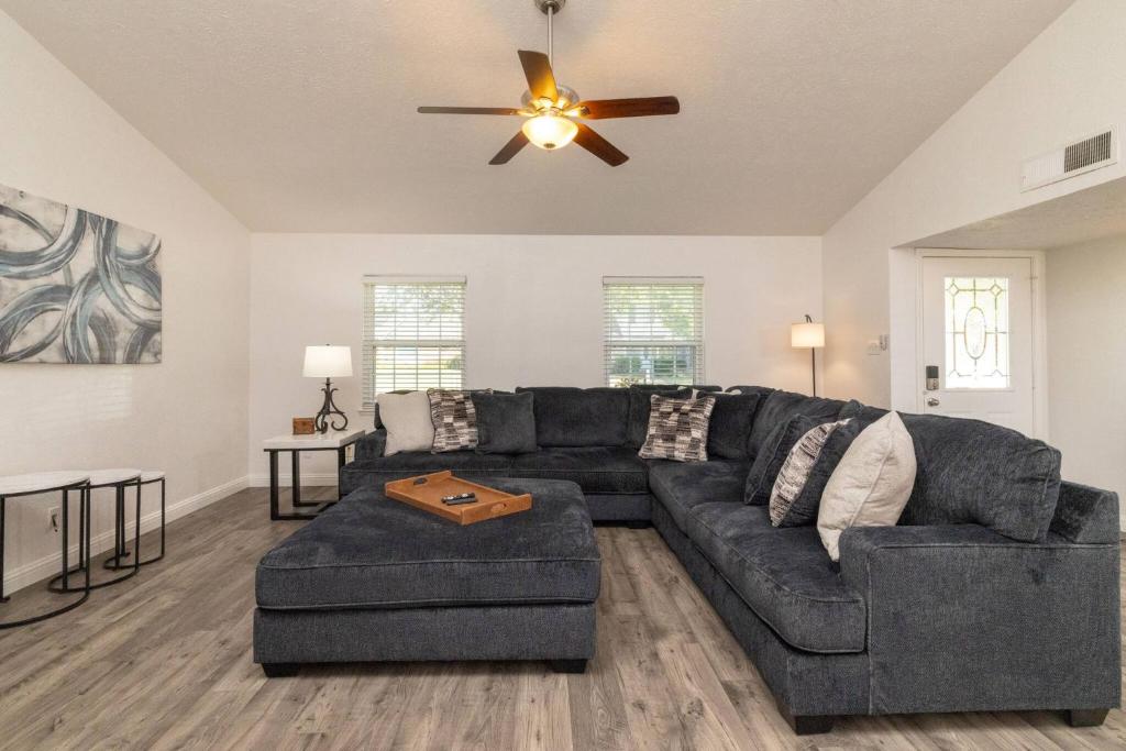 a living room with a couch and a ceiling fan at Private Pool - Game Room - Backyard TV - Fenced Yard in Plano