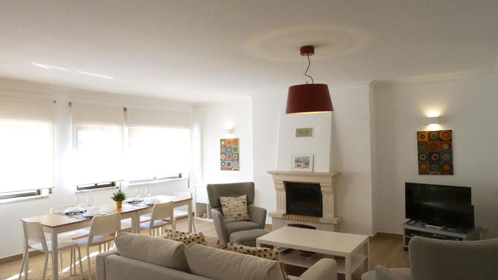 a living room with a couch and tables and a fireplace at Sister's House by east ALgarve guest in Tavira