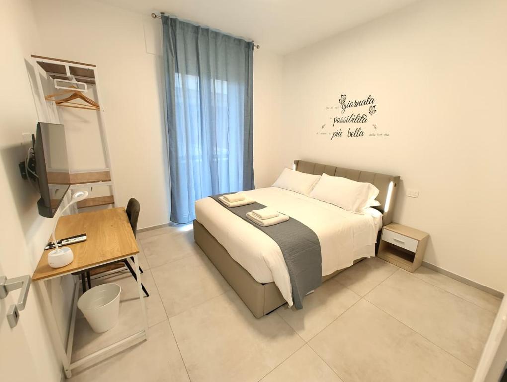 Un dormitorio con cama, escritorio y televisión. en Baracca Space Apartments, en Florencia
