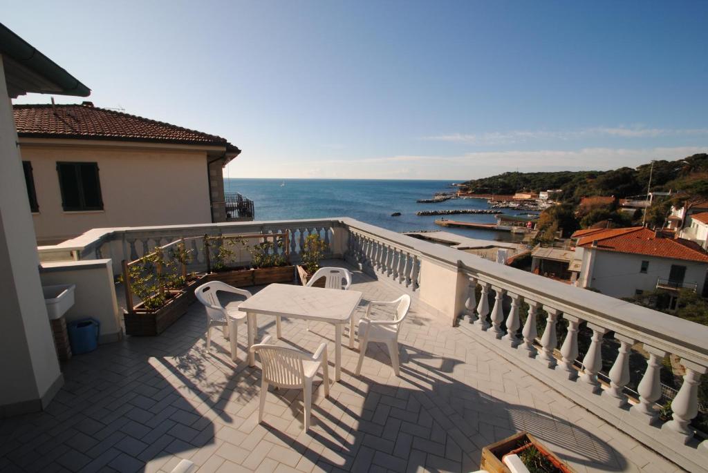 einen Balkon mit einem Tisch, Stühlen und Meerblick in der Unterkunft Villa Fiorella in Castiglioncello