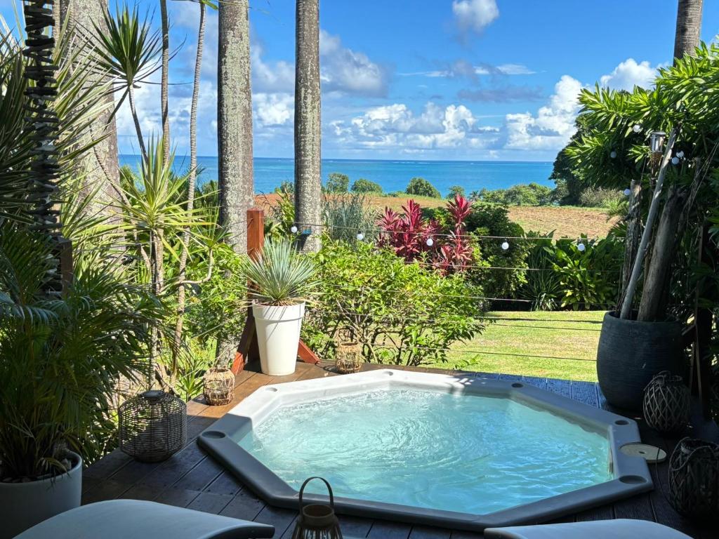 - un bain à remous sur une terrasse avec vue sur l'océan dans l'établissement Indigo Palmes, à Sainte-Rose