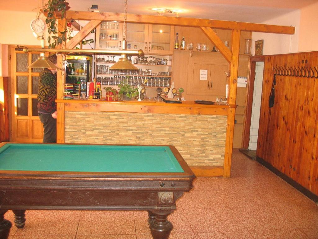 uma mesa de bilhar num quarto com um bar em penzion - restaurace Na Výšince em Turnov