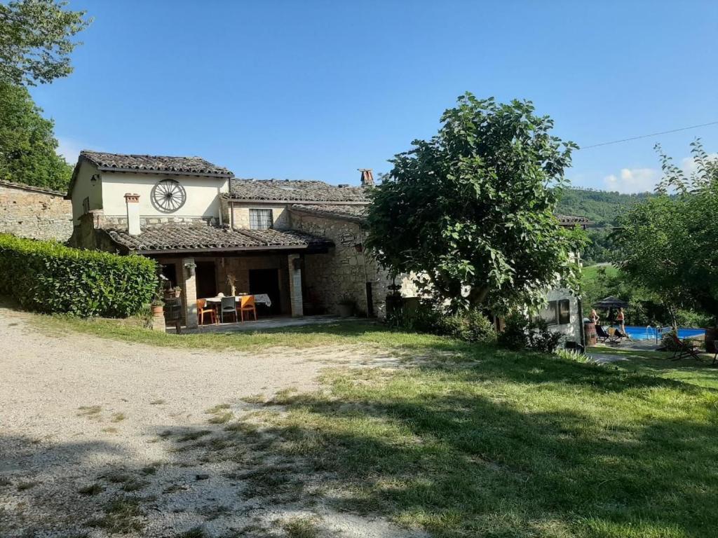 a house with a clock on the side of it at Holidays Catassino in Urbino