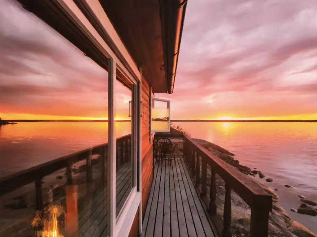 a house with a view of the ocean at sunset at Archipelago Hideaway - Oasis on the Sea in Värmdö