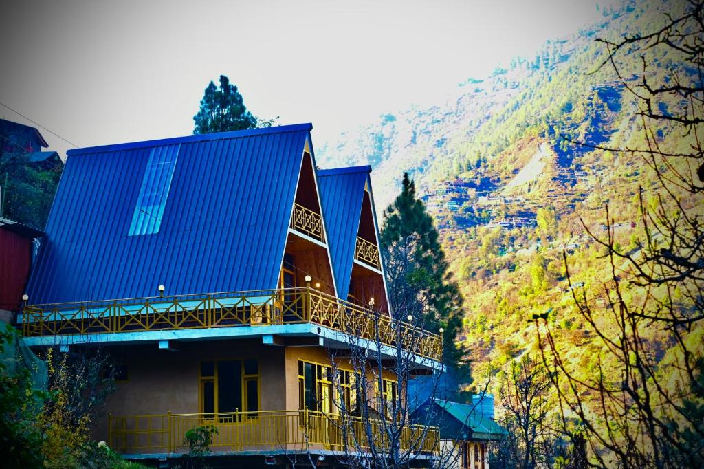 un edificio con il tetto blu su una montagna di the clifton chapter tirthan a Banjār