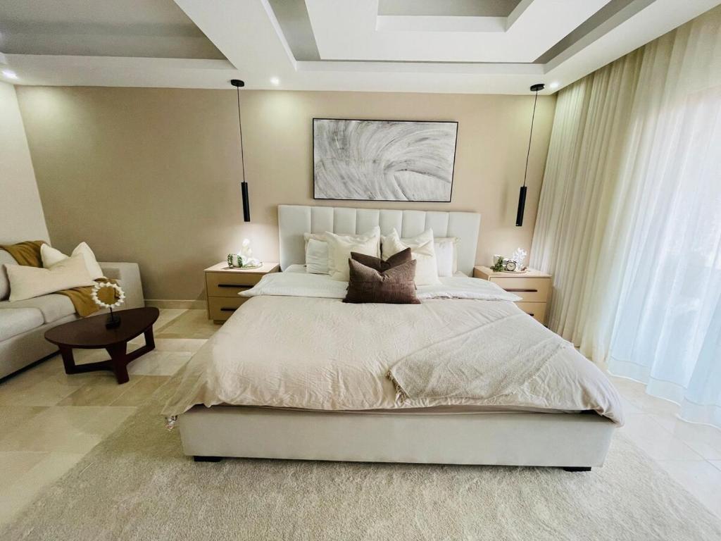 Puerto PlataMarien Residences 305 Deluxe High Floor Condo的卧室里有一张白色的大床和一张沙发