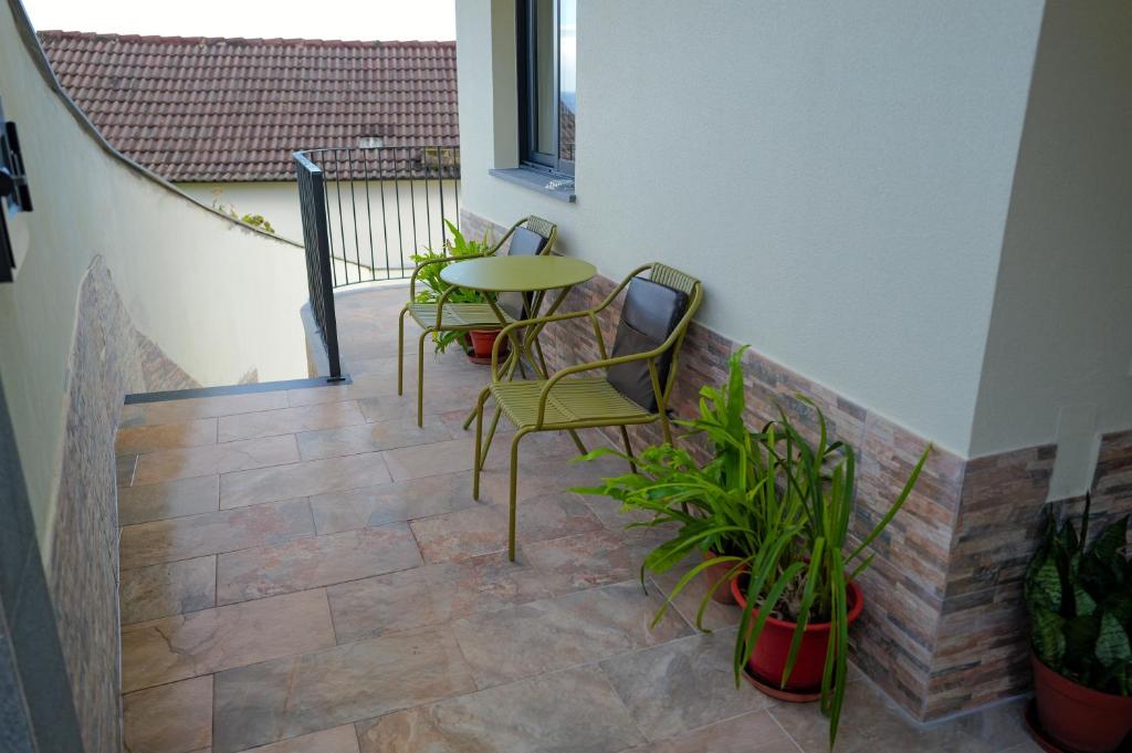 a patio with chairs and a table and some plants at Vivenda Silva in Seixal