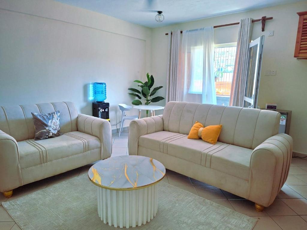 Una sala de estar con dos sofás y una mesa. en Evara staycation, en Shanzu