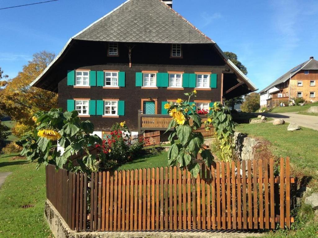 ein Haus mit einem Holzzaun davor in der Unterkunft Maierhof in Bernau im Schwarzwald