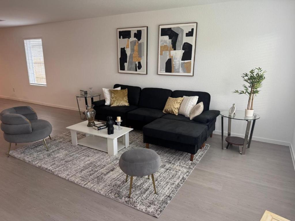 Una sala de estar con un sofá negro y una mesa. en new and beateful house, en Hockley