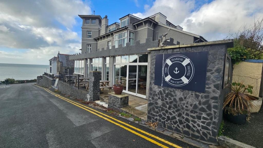 a building with a sign on the side of a street at The Marine Hotel in Criccieth