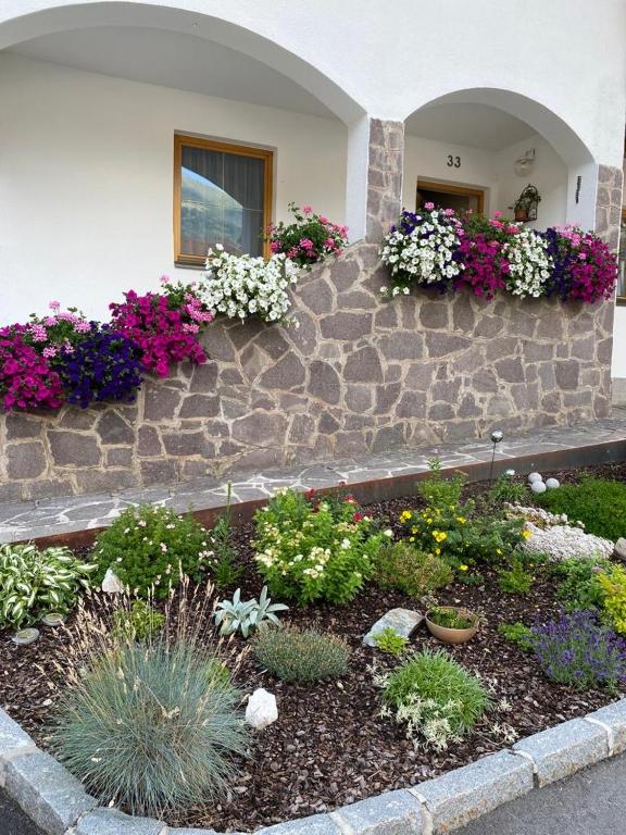 a garden with flowers on the side of a building at Ferienwohnung Eichhorner in Außervillgraten
