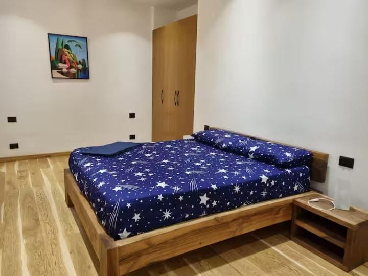 a bedroom with a bed with a blue comforter at Queen Barbara in Genoa