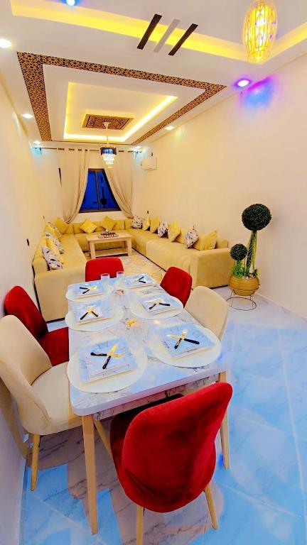 a living room with a table and red chairs at Luxuriöse Wohnung in Fez in Fez