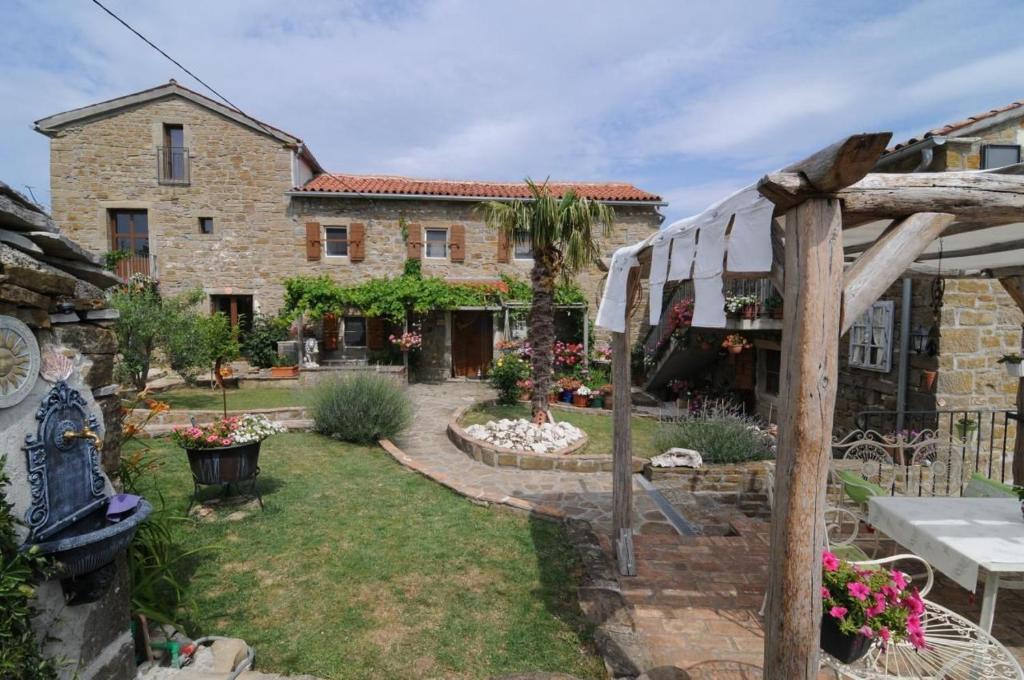 a garden in front of a stone house at Villa Casa Sarina in Brdo