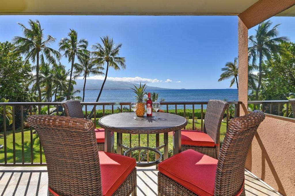 - une table et des chaises sur une terrasse donnant sur l'océan dans l'établissement Maalaea Banyans 203 · MBN 203 OceanFront 1BD Amazing Ocean Views, à Wailuku