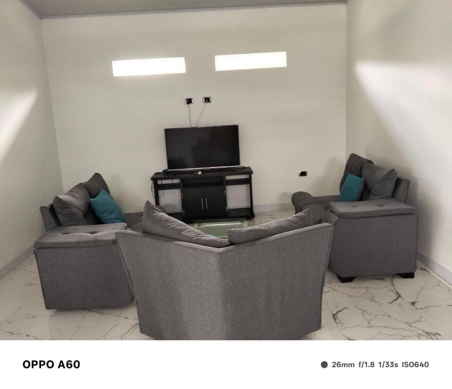 un soggiorno con due divani e una TV a schermo piatto di Casa Bella Mansion a Nariño