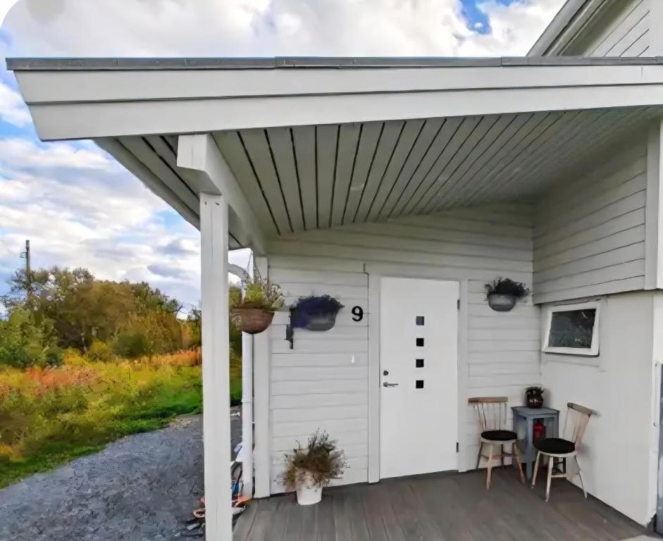 une pergola blanche sur une maison blanche avec terrasse dans l'établissement Villa Utsikten, à Bø
