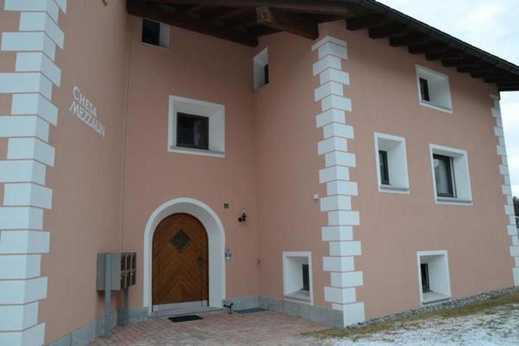 Un gran edificio con una puerta de madera. en Familie Frei, en Bever