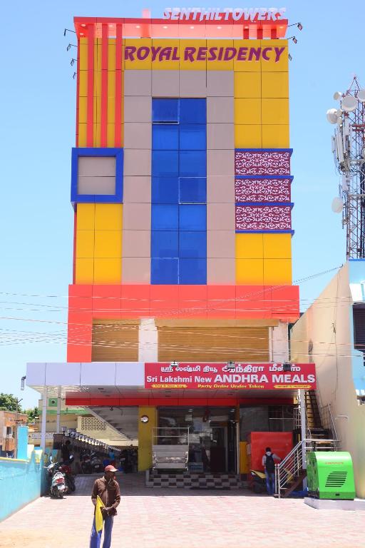 a man standing in front of a colorful building at Royal Residency in Pedappai