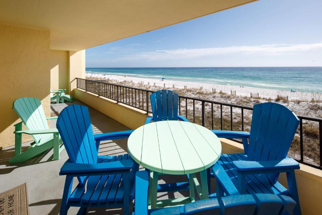 a table and chairs on a balcony with the beach at Surf Dweller 312 Large gulf front in Fort Walton Beach