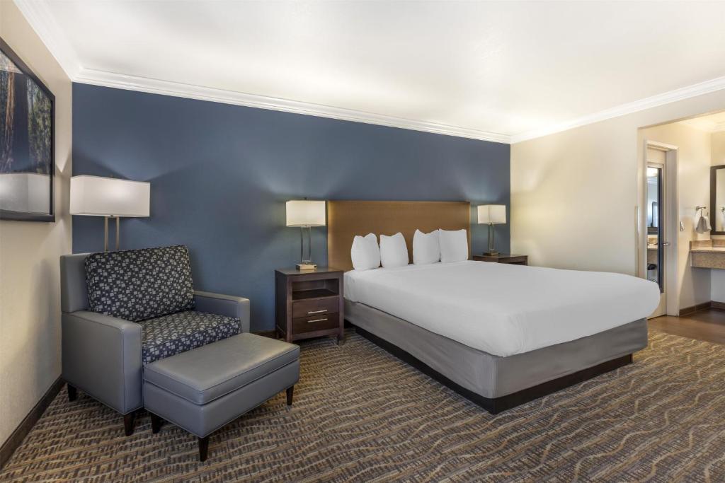 a hotel room with a bed and a chair at Best Western Town & Country Lodge in Tulare
