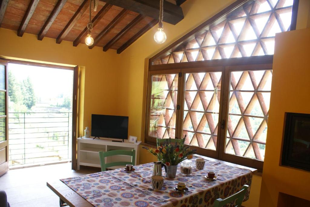 une salle à manger avec une table et une télévision dans l'établissement Sunset Barga Toskana Kürzlich Renoviert, à Barga
