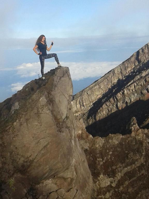 a woman standing on top of a rock at Pondok Lembah Dukuh Homestay in Tirtagangga